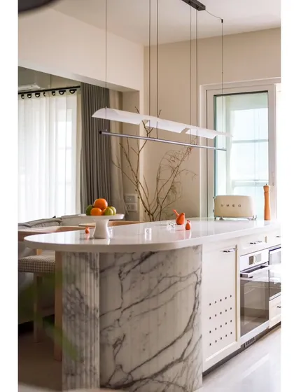 A linear suspended light fixture hangs delicately above the breakfast counter, providing functional light without overpowering the space. It's a perfect example of our 'less is more' philosophy.