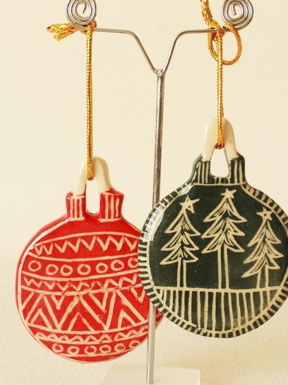 Another pair of my popular red and green carved ornaments, showcasing different festive designs. They look beautiful hanging side-by-side on a Christmas tree.