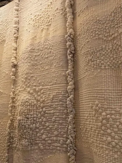 A close-up of the highly textured, hand-worked fabric from the 'Sleep Sense' installation. The piece is designed to be a tactile experience, evoking the comfort of a traditional quilt.