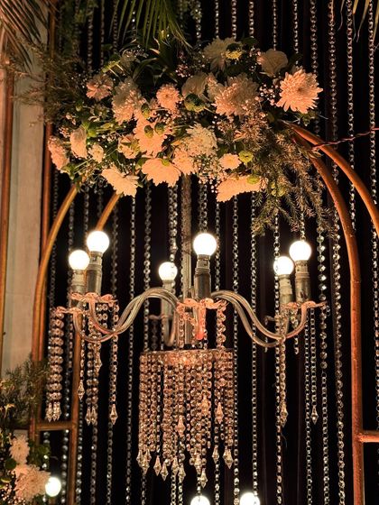 The chandelier and floral arch detail, a perfect example of the small, artistic touches that make a wedding decor special.