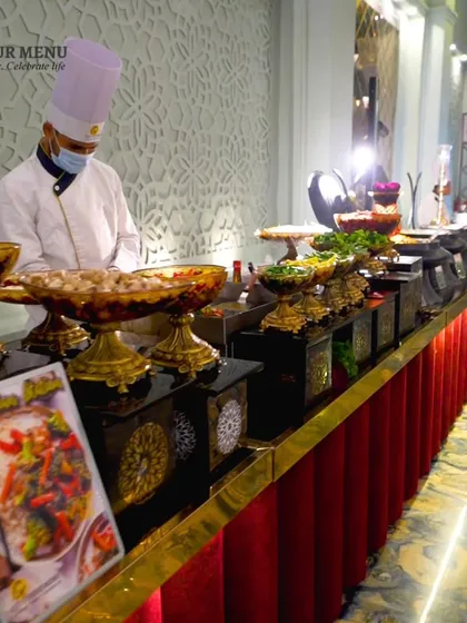 A wide shot of our impressive Chinese food counter, with a chef ready to serve guests from a variety of beautifully presented dishes.