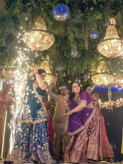 A Sangeet is a celebration for the whole family. Here, guests join the couple on stage with sparklers, dancing under a canopy of greenery and chandeliers for a truly magical group performance.