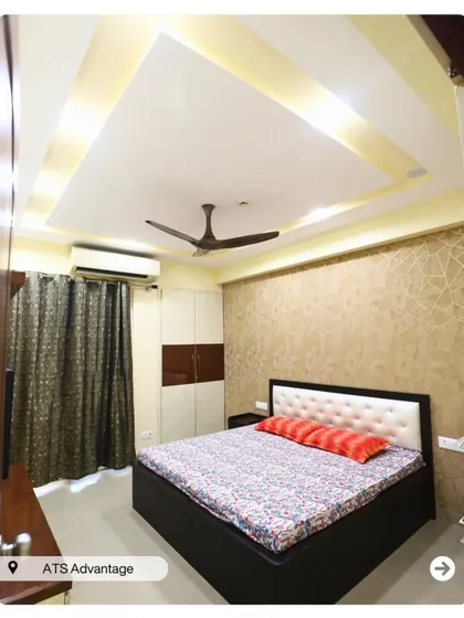 A bedroom with a simple, clean aesthetic. The textured wallpaper and two-toned wardrobe provide visual interest without cluttering the space.