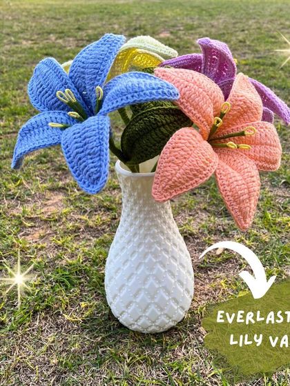 An everlasting lily vase. This arrangement of colorful crochet lilies in a white vase is a perfect, elegant centerpiece for any room.