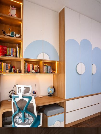 A fun and functional kid's bedroom from our Japandi-themed villa project. The wardrobe features cloud-like blue curves, and the study area has ample open shelving for books and toys.