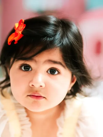 A stunning close-up portrait. Her big, curious eyes and the soft focus on the background highlight her innocent beauty. This shows my skill in capturing classic portraits.