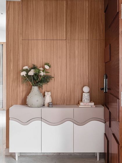 In line with the Japandi aesthetic of the Kābu home, we created this minimalist foyer cabinet with defining waves and a color-blocked finish. The chic cabinet adds charm to the compact entryway, with a wooden wall panel behind it acting as a great backdrop.