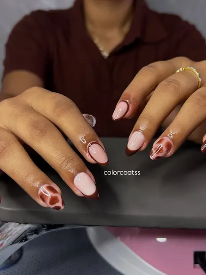 A full two-hand view of the tortoiseshell and brown French tip combination. This shows how we can mix and match different art on each nail for a completely custom look.