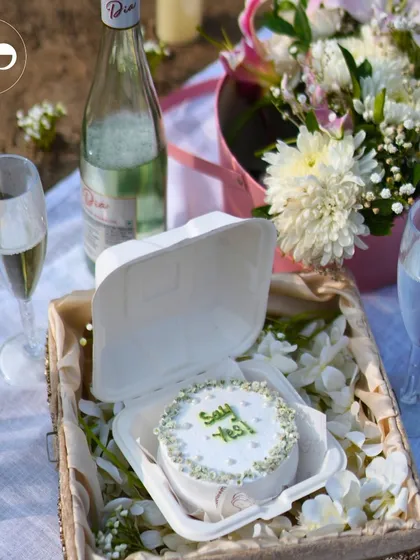 Crafting the perfect beachside proposal starts with personal touches. A custom "Say Yes" cake, chilled champagne, and a beautiful floral arrangement create a simple yet unforgettable setting for a magical question.