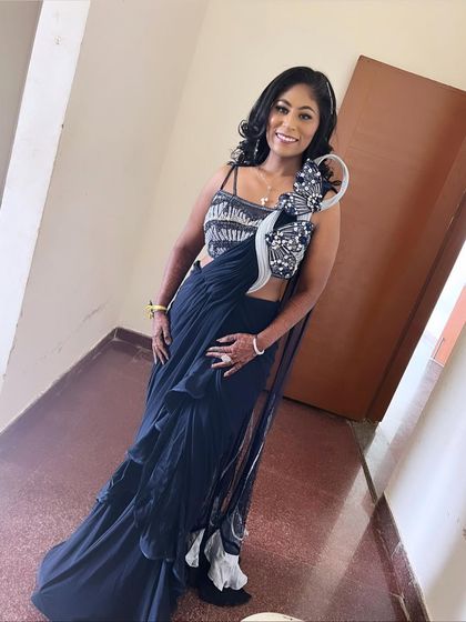 A modern, chic reception look. The ruffled saree and statement blouse are paired with soft curls and glamorous makeup.