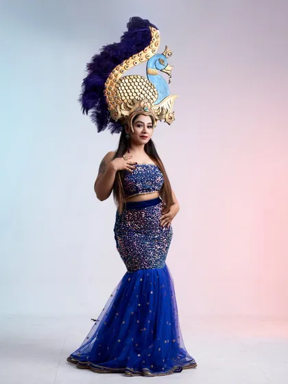 A stunning peacock-themed costume, featuring a sequined blue mermaid-style dress and an elaborate, handcrafted peacock headdress. This is a one-of-a-kind rental for a memorable shoot.
