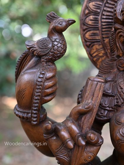 A close-up of the hand of Abhinaya Saraswathi holding a small parrot, a symbol of speech and artistry.
