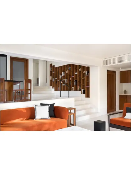 This view shows how the custom bookcase connects the different levels of the home. It is a piece of furniture that is fully integrated with the architecture, defining the character of the space.