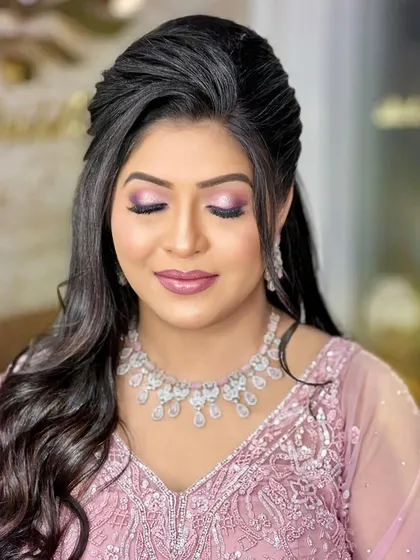 A lovely engagement look featuring a soft pink gown. The bride is wearing a sparkling diamond necklace that perfectly complements her romantic and elegant style.
