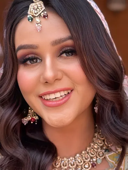 A bright and cheerful close-up of the bride. Her makeup is fresh and dewy, with a natural pink lip that is perfect for a Haldi ceremony.