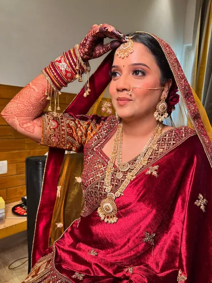 A candid shot of my bride adjusting her dupatta, looking regal in her red velvet lehenga.