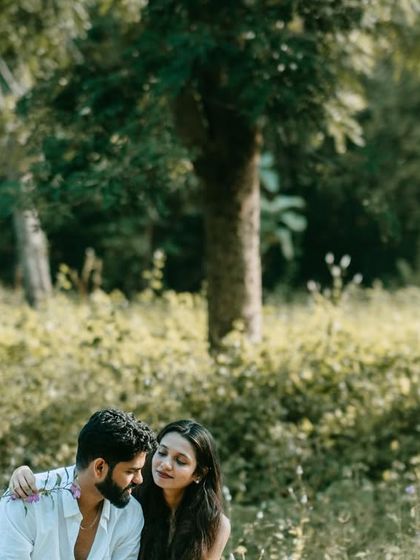 A beautiful, wide shot of the couple sitting in a field of green. It captures the peace and quiet of being away from the city.