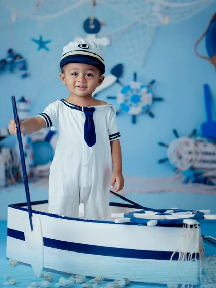 Ready to set sail, this little captain stands confidently in his boat prop. Our themed sessions are designed to empower little ones and capture their adventurous spirit.