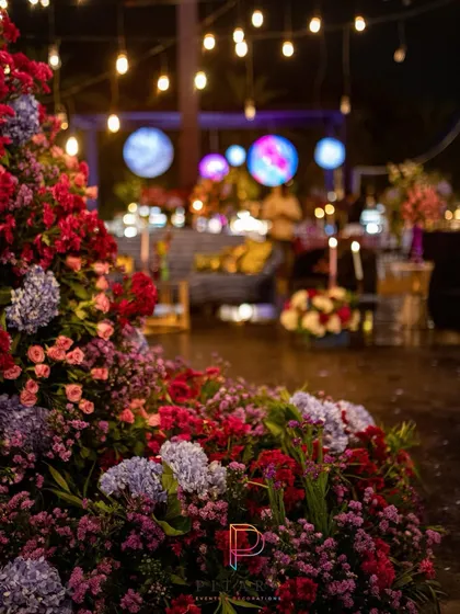 A beautiful chaos of florals in the foreground, with the cosmic-themed bar and hanging planets visible in the background. This shot captures the layers of color and light that made the event so dynamic.