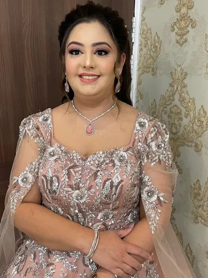 A beautiful client ready for a party. Her hair is styled in a classic updo, and her makeup is glamorous and perfectly applied.
