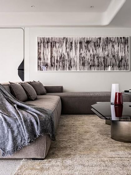 A detail of the informal living area in Apartment 56, where a deep lounge sofa and abstract art create a comfortable yet curated space. The design prioritizes clean lines and a focus on the expansive feel of the room.