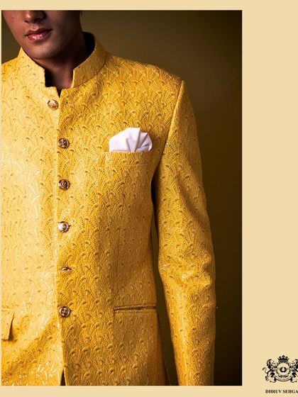 A detailed shot of a yellow Jodhpuri jacket. The self-textured fabric and custom buttons are examples of the small details that create an overall impression of luxury.