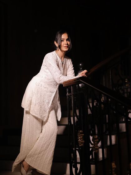 A clear, full-length shot of the white co-ord set on the stairs, showing its classic and elegant design.