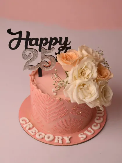 Celebrating a 25th birthday with this pretty pink cake. It features a delicate lace-like texture on the side, a bouquet of fresh peach and white roses, and a glittering silver "Happy 25" topper.