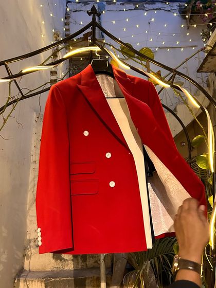 The red blazer on display. The rich color and classic double-breasted cut make it a timeless piece for special occasions.