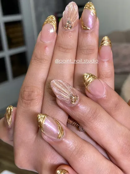 A different angle of the intricate gold-wrapped nails, showing the texture and detail of the design.