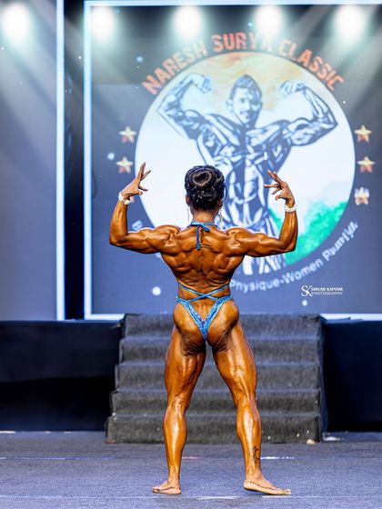 The rear double bicep pose, executed with power and grace. This is the result of dedicated back and arm training.