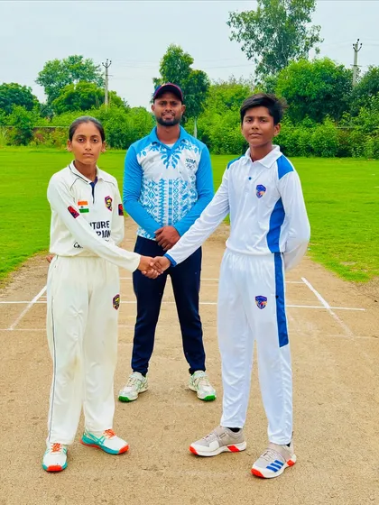 The coach stands with the two captains at the toss, a picture of mentorship and fair play.
