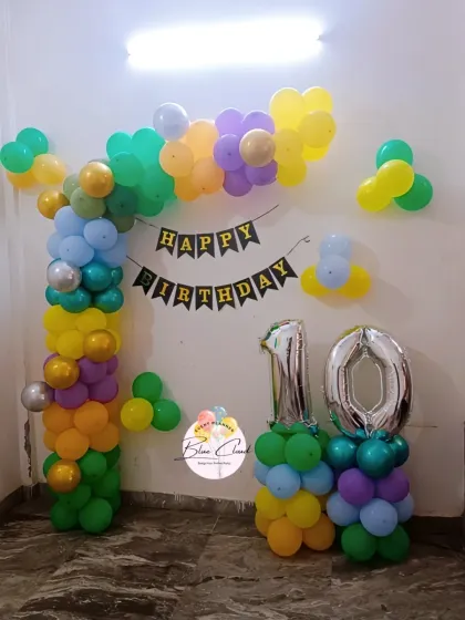 A colorful balloon arch with number '10' foils for a birthday party at home.