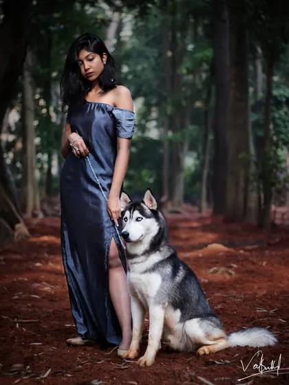 A conceptual shoot bringing the 'Beauty and the Beast' fairytale to life in a moody forest setting. This portrait captures the powerful yet gentle connection between the model and the majestic Siberian Husky, creating a truly cinematic narrative.