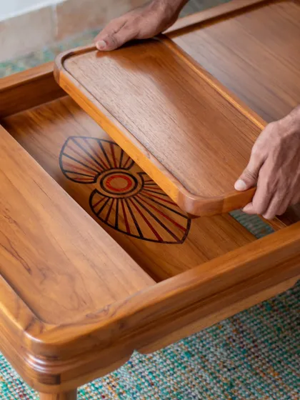 A close-up of the intricate Mysore wood inlay work on our center table. Inspired by the colorful costumes of Yakshagana, a folk dance from Coastal Karnataka, this traditional craft turns the furniture into a piece of regional heritage.