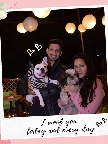 "I woof you today and every day." A couple holds their two small dogs, celebrating their love at our cafe.