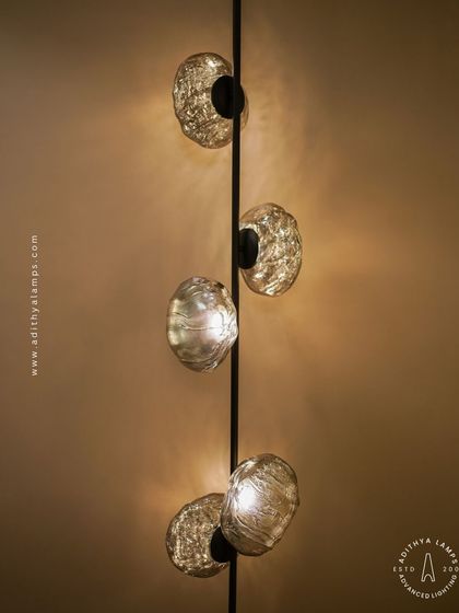 This vertical fixture features textured, moon-like chrome orbs attached to a central black rod. It's a striking, artistic piece that works well in corners or narrow spaces, adding a touch of celestial-inspired modernism.