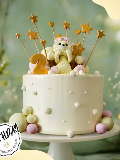 A starry and sweet cake for a 2nd birthday. This design features a cute teddy bear surrounded by stars and pastel-colored balls.