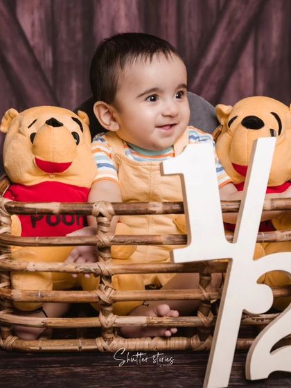 Another angle from the Winnie the Pooh half-birthday shoot, capturing a happy, candid moment.