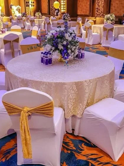 A wide view of the guest seating area, showing the coordinated table settings and chair decorations that carry the royal theme throughout the entire venue.