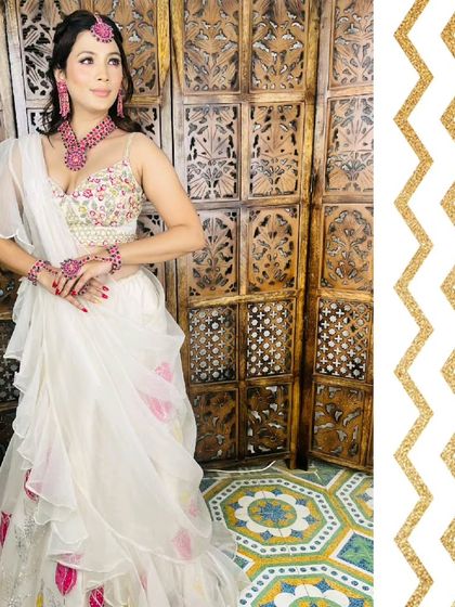 This white Indo-Western lehenga with a ready-to-wear ruffle dupatta is perfect for a haldi or mehendi function. The pop of pink from the jewellery adds a beautiful contrast.