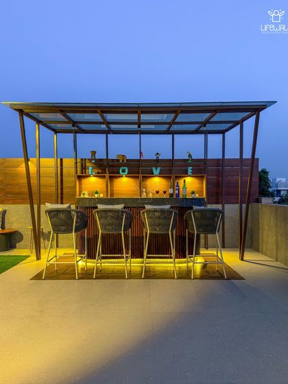 A close-up of a romantic and stylish bar setup. The design features a wooden back shelf with the word "LOVE," under-counter lighting, and elegant bar stools, perfect for evening cocktails.