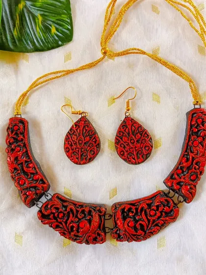 A bold red and black version of the carved 'hansli' necklace. The color is powerful, and the intricate carving adds a layer of sophistication.