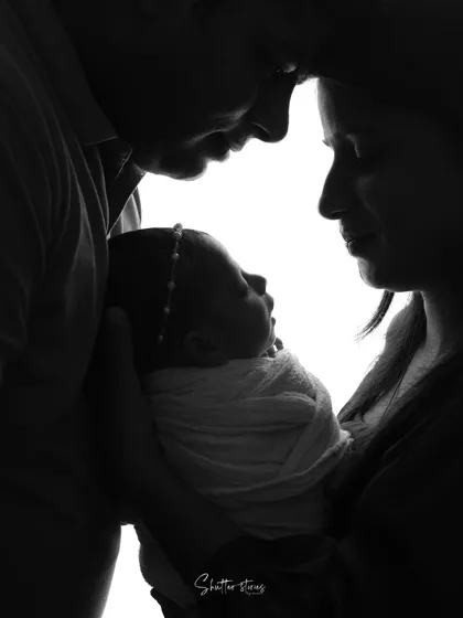 Sometimes, the most powerful stories are told in silhouette. This black and white family portrait focuses on the connection and love between new parents and their baby, creating a timeless piece of art.