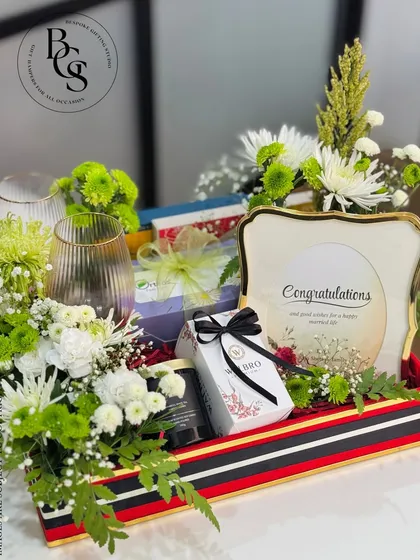 A congratulations hamper perfect for an anniversary or housewarming. This tray includes two wine glasses, fresh flowers, and a personalized photo frame to capture a special memory.
