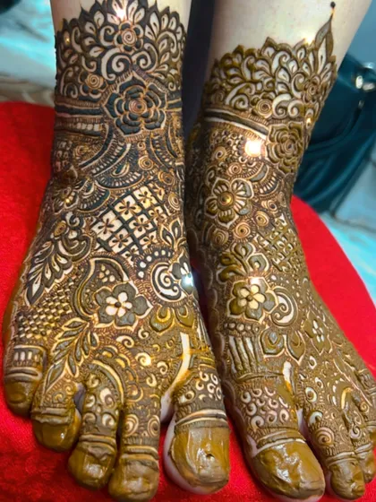 A close-up of a heavy bridal feet design. The pattern is dense with floral and paisley motifs.