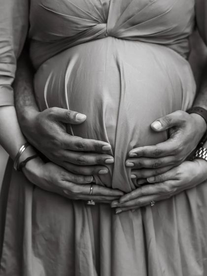 A duplicate of ID 29, this close-up, black and white shot focusing on the couple's hands cradling the baby bump symbolizes their shared love and protection.