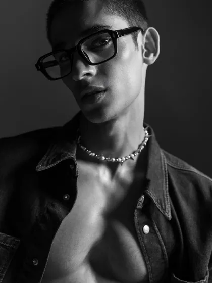 A striking black and white portrait from the same series. The use of glasses and a pearl necklace adds a contemporary, intellectual vibe to the rugged denim look.