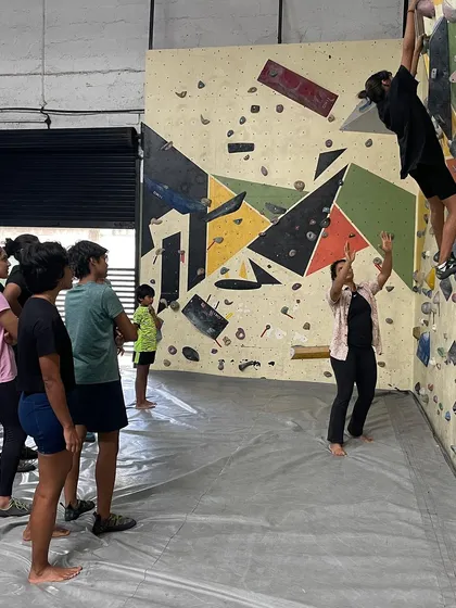 An instructor spotting a climber during a gym session. We provide hands-on guidance to help you feel secure and confident as you learn.