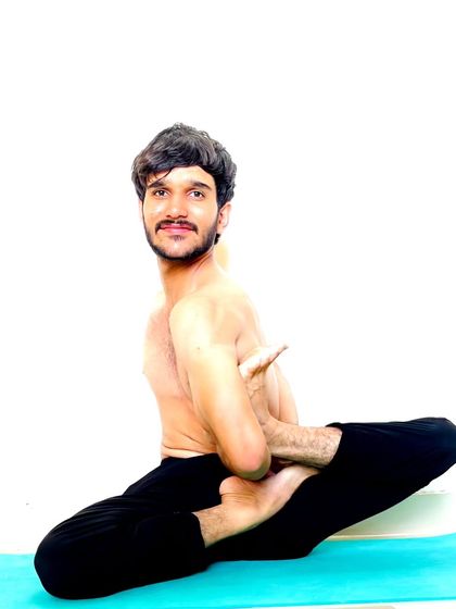 A seated balancing pose with a bind, demonstrating core control and focus.